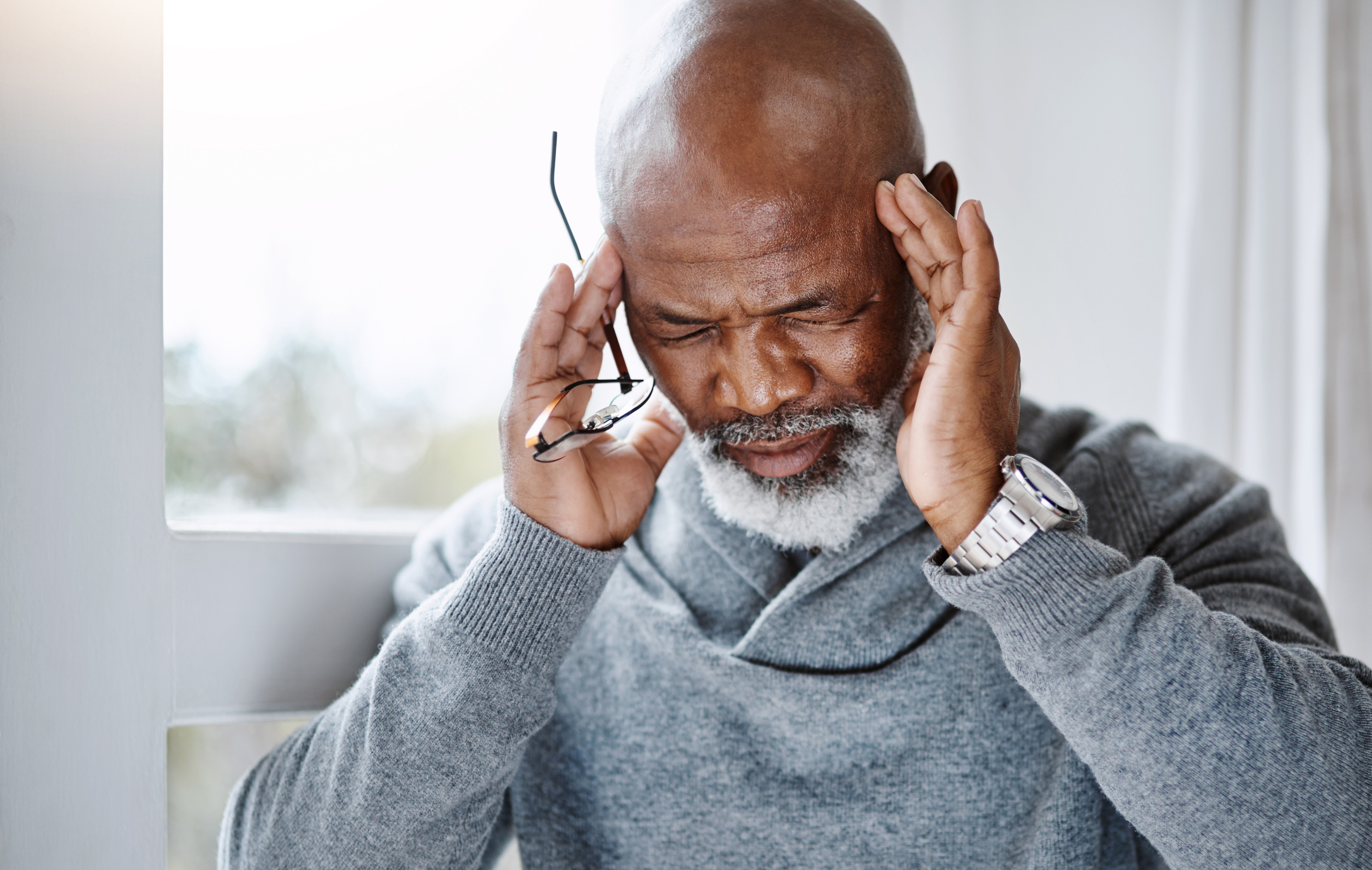 Man touching his temples after experiencing migraine symptoms