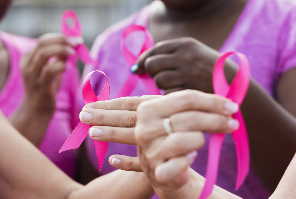 Group of women holding pink breast cancer awareness ribbons