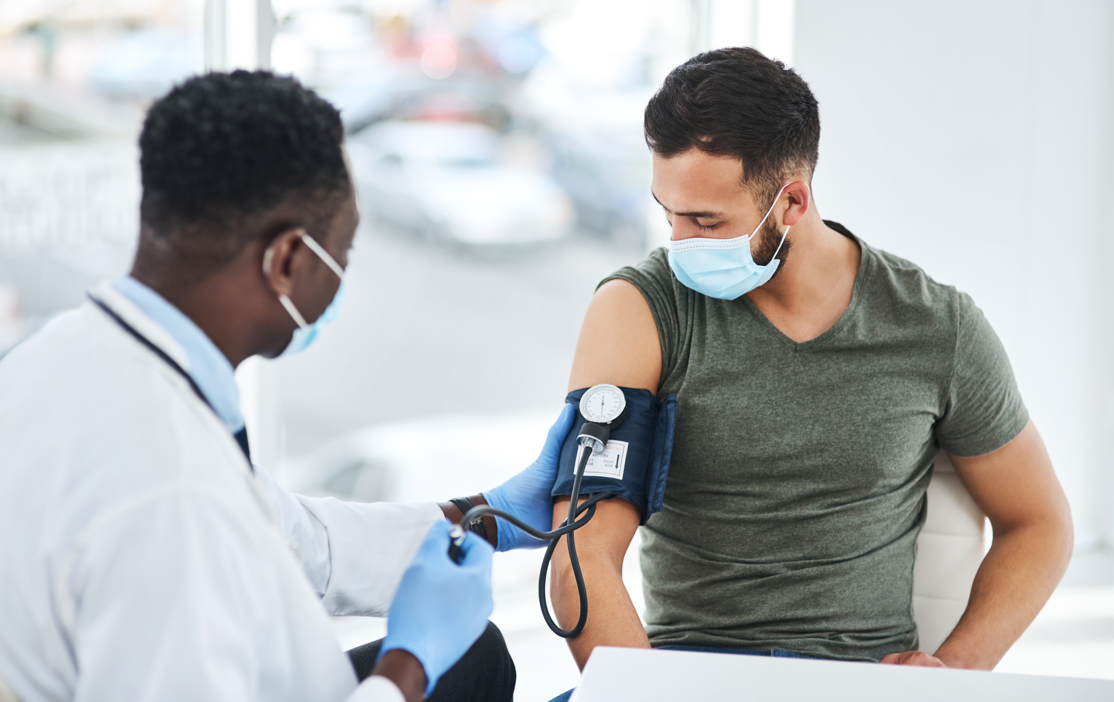 Medical professional monitoring a patient's blood pressure for signs of hypertension