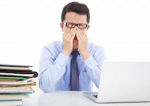 man rubbing his eyes
